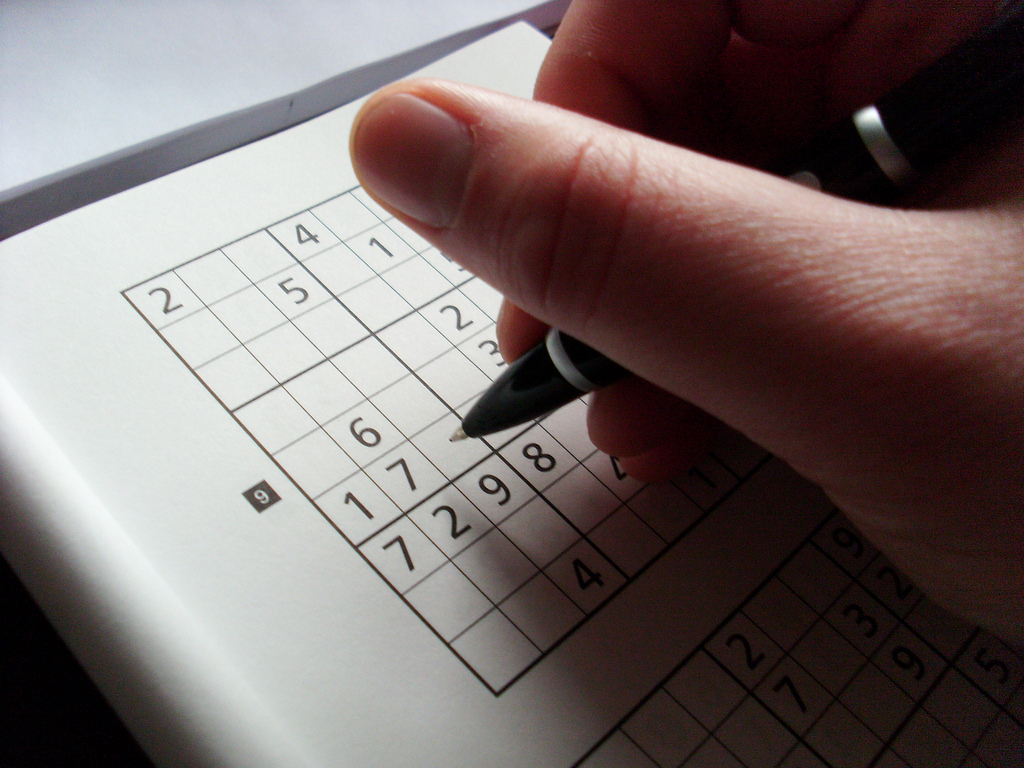 Man Writing His Answers on a Sudoku Sheet Using Ballpen for 247 Sudoku Relaxation Game