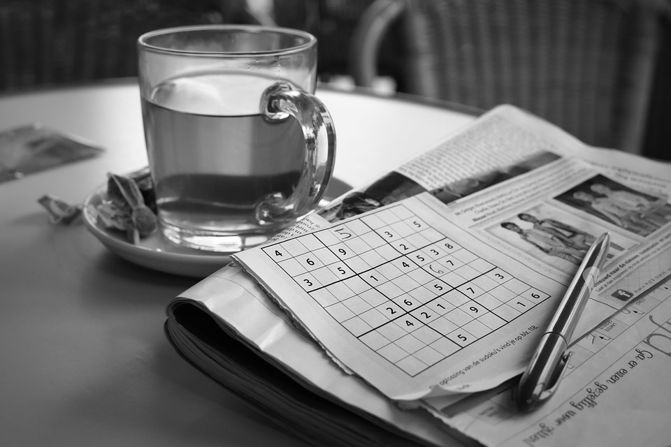 Sudoku Sheet and a Newspaper with a Tea on a Table for 247 Sudoku Relaxation Game