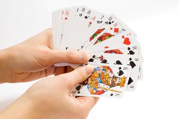 person's hand holding cards